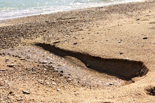 A fresh water spring flows from the beach. - MyVideoimage.com