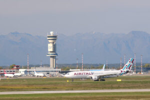 Air Italy Airbus Airbus A330-202 airplane on the Malpensa airport runway. In the background the buildings of Terminal 1 and parked airplanes. - MyVideoimage.com