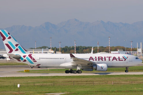 Air Italy Airbus Airbus A330-202 airplane on the Malpensa airport runway. In the background the buildings of Terminal 1 and parked airplanes. - MyVideoimage.com