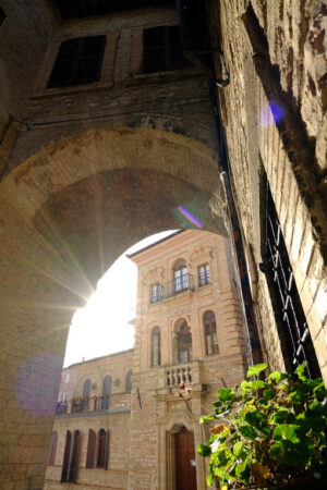 Alley in Assisi with arch. Alley of the city of Assisi with arch and vault. The walls of the houses are built with light colored stone. - MyVideoimage.com | Foto stock & Video footage