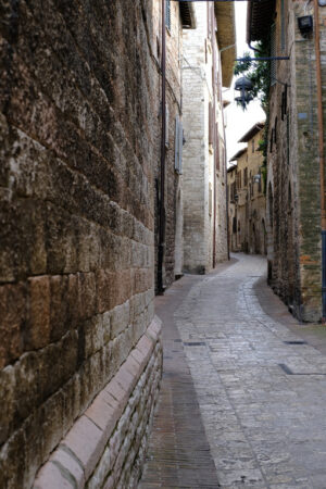 Alley of the city of Assisi with stone facades of historic houses. 	Narrow alleys of the city with the walls of the stone houses. Deserted road. - MyVideoimage.com | Foto stock & Video footage