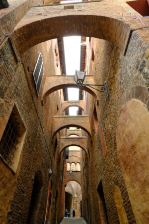 Alley with arches in the Tuscan city of Siena. Terracotta brick walls of the ancient houses. - MyVideoimage.com | Foto stock & Video footage