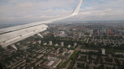 Amsterdam panorama. Airplane in landing phase. Detail of the wing. Panorama from abo - MyVideoimage.com | Foto stock & Video footage