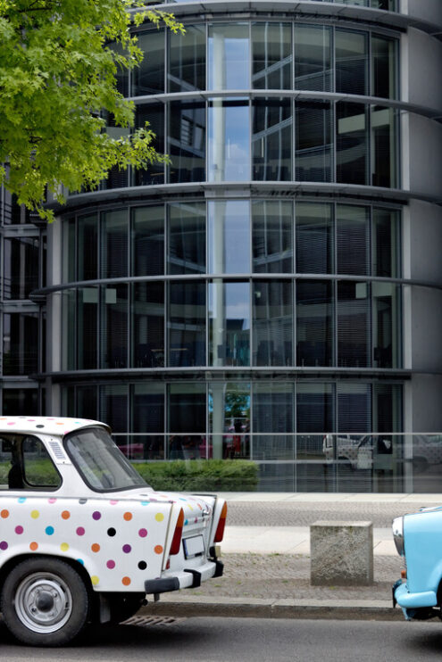 Ancient Trabant car. Vintage Trabant high-buildings parked. Foto automobili. Cars photos.