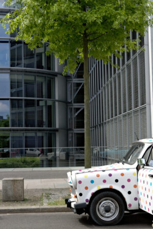 Ancient Trabant car. Vintage Trabant high-buildings parked. Foto automobili. Cars photos.