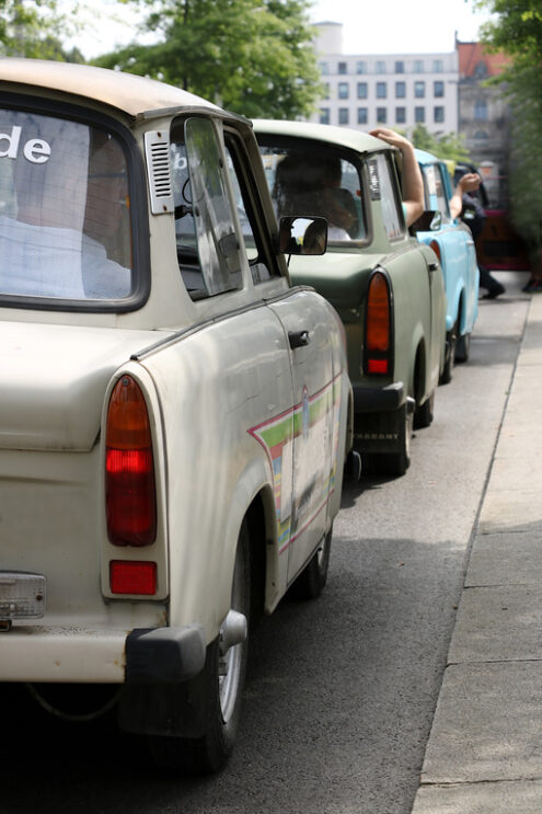 Ancient Trabant car. Vintage Trabant high-buildings parked. Foto automobili. Cars photos.