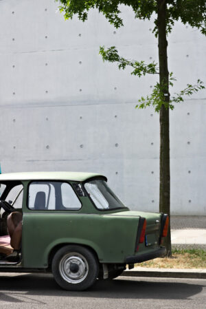 Ancient Trabant car. Vintage Trabant high-buildings parked. Foto automobili. Cars photos.