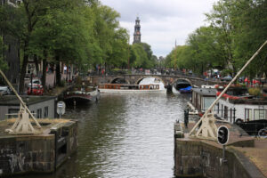 Ancient bridge on an Amsterdam canal. A boat runs along the cana - MyVideoimage.com