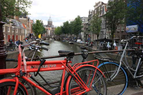 Ancient bridge on an Amsterdam canal. A boat runs along the cana - MyVideoimage.com