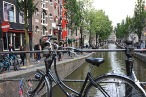 Ancient bridge on an Amsterdam canal. A boat runs along the cana - MyVideoimage.com