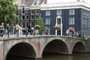 Ancient bridge on an Amsterdam canal. A boat runs along the canal. Amsterdam foto. Amsterdam photo