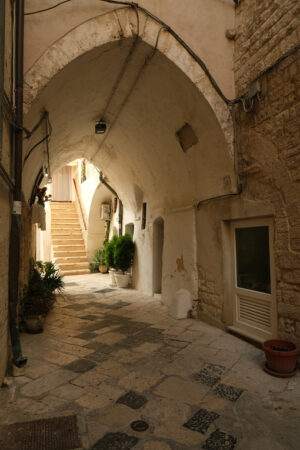 Ancient houses in the alleys of the city of Bari. Ogival vault in an alley. Marble flooring. - MyVideoimage.com