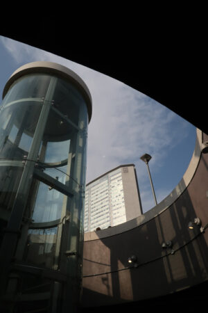 Ascensore panoramico a Milano. Panoramic lift with glass facade. In the background the Pirelli skyscraper in Milan. Central Station. - MyVideoimage.com | Foto stock & Video footage