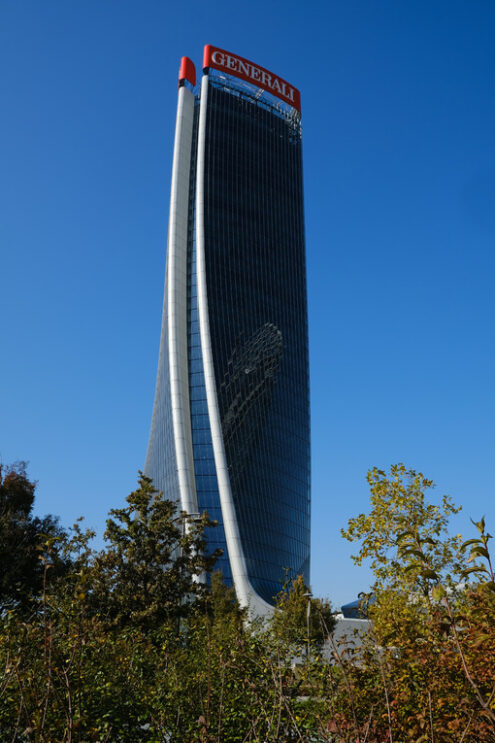 Assicurazioni Generali Milan. Skyscrapers. Assicurazioni Generali skyscraper with the blue sky background and trees with green leaves. Società. Company building. - MyVideoimage.com | Foto stock & Video footage