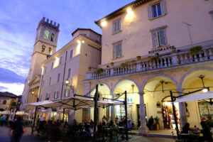 Assisi di notte. Piazza con torre. Town square of Assisi with the Torre del Popolo and fountain at night. The city of San Francesco with the lights of the night. - MyVideoimage.com | Foto stock & Video footage