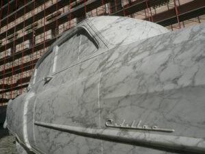 Automobile in marmo bianco. Sculpture depicting a Cadillac car made of white Carrara marble displayed in a town square. - MyVideoimage.com | Foto stock & Video footage