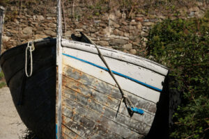 Barca in secca in Liguria. Gozzo, a typical wooden boat from Liguria pulled ashore in a square in the Cinque Terre. - MyVideoimage.com | Foto stock & Video footage