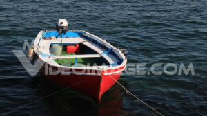 Barca rossa. Red-colored boat anchored at the sea port. Video footage.