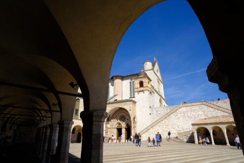 Basilica Assisi dedicata a San Francesco. Church of San Francesco in Assisi and the square with the arcade. The basilica built in Gothic style consists of a lower and an upper church. - MyVideoimage.com | Foto stock & Video footage