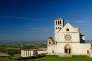 Basilica of San Francesco with the lawn with green grass in front and the blue sky. - MyVideoimage.com