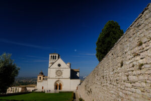 Basilica of San Francesco with the lawn with green grass in front and the blue sky. - MyVideoimage.com