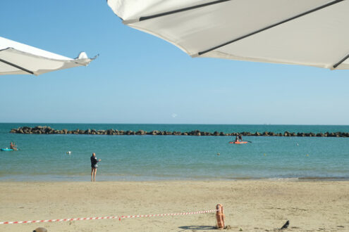 Beach with umbrella. Panorama of the sea and the beach through a white umbrella. Stock photos. - MyVideoimage.com | Foto stock & Video footage