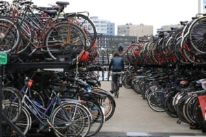 Bicycle parking at Amsterdam Central Station. A woman on a bike - MyVideoimage.com