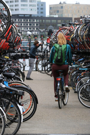 Bicycle parking at Amsterdam Central Station. A woman on a bike - MyVideoimage.com