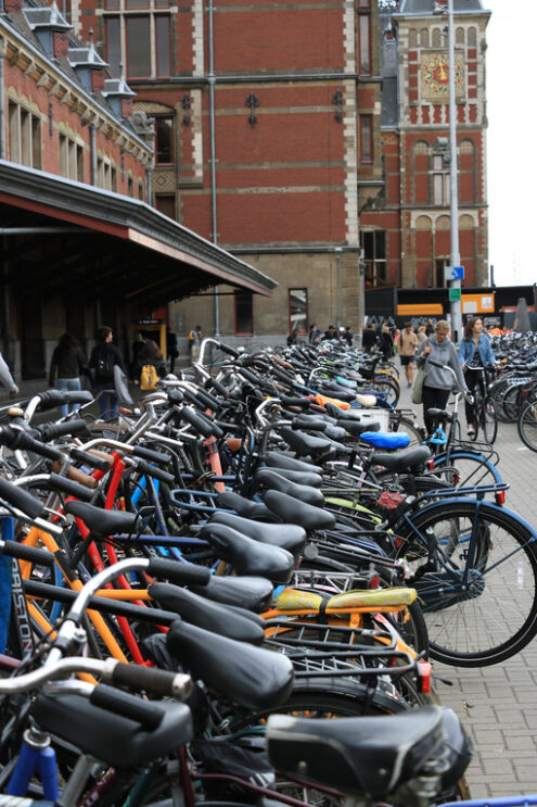 Bicycle parking at Amsterdam Central Station. A woman on a bike - MyVideoimage.com