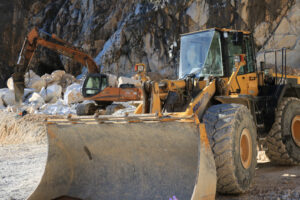 Big excavator in quarry. Excavator and a bulldozer in a Carrara marble quarry. Cave marmo. - MyVideoimage.com | Foto stock & Video footage