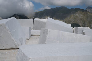 Blocchi di marmo grezzo. Blocks of white Carrara marble deposited in a square near the quarries. Foto stock royalty free. - MyVideoimage.com | Foto stock & Video footage