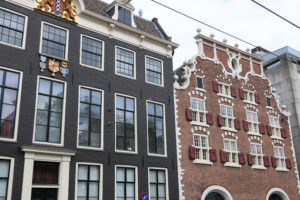 Brick houses in Amsterdam. Typical red and gray brick houses with large white windows. - MyVideoimage.com | Foto stock & Video footage