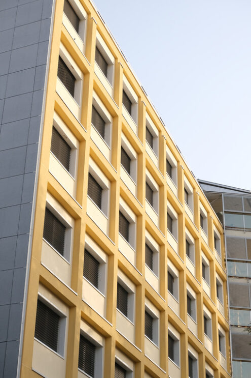 Brutalist building. Building facade with modern period windows and frames. Pillars and beams painted in yellow. - MyVideoimage.com | Foto stock & Video footage