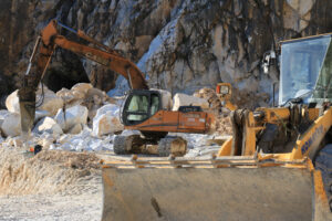 Bulldozer in a quarry. An excavator and a bulldozer in a Carrara marble quarry. A large excavator and a bulldozer in a marble quarry in the Apuan Alps. - MyVideoimage.com | Foto stock & Video footage