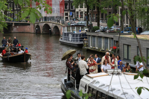 Canal party. A family celebrates on the boat in the city center. - MyVideoimage.com