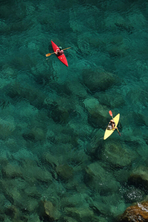 Canoe alle Cinque Terre. Colorful canoe on the transparent sea of the Cinque Terre. Top view with sea bottom with rocks and pebbles. - MyVideoimage.com | Foto stock & Video footage