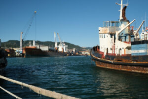 Cargo ship loading at the port of La Spezia. In the foreground an old ship cart of the sea. Foto navi. Ships photo.