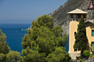 Casa con torre alle Cinque Terre. Seascape with house turret near the Cinque Terre. In the village of Framura a villa with a tower overlooking the blue sea and dense Mediterranean vegetation. - MyVideoimage.com | Foto stock & Video footage