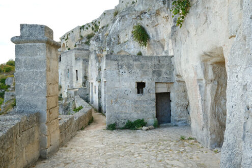 Case di Matera. Road and facades of the Sassi of Matera. Doors and windows of ancient underground houses carved into the tuff rock. - MyVideoimage.com | Foto stock & Video footage