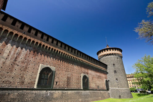 Castello Sforzesco Milano. Sforza Castle in Milan. Cylindrical tower and walls. The Castle with the walls and the background of the blue sky of a spring day. - MyVideoimage.com | Foto stock & Video footage