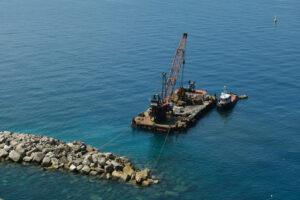 Chiatta con gru sul mare. Barge with crane for dredging the seabed at the port of Riomaggiore, Cinque Terre, royalty free - MyVideoimage.com | Foto stock & Video footage