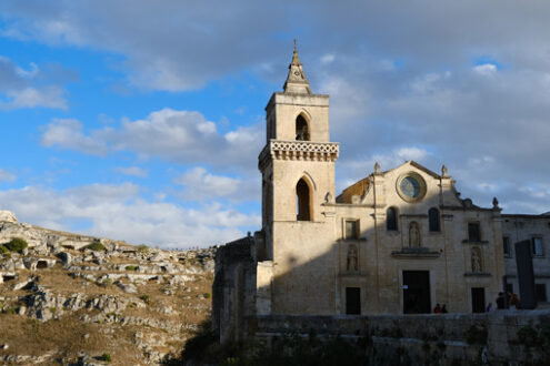 Chiesa di San Pietro Caveoso, Matera. Church of San Pietro Caveoso in Matera. In the background the Mountains with ancient prehistoric caves. - MyVideoimage.com | Foto stock & Video footage