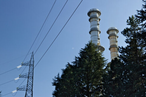 Chimneys and electric pylons behind treesTurbigo. - MyVideoimage.com