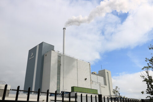 Chocolate factory. Cocoa refining plant. Chimney with smoke in blue sky with clouds - MyVideoimage.com | Foto stock & Video footage