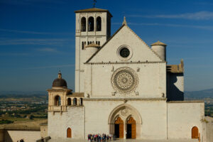 Church of San Francesco in Assisi with the stone wall. The basilica built in Gothic style houses the frescoes by Giotto and Cimabue. - MyVideoimage.com