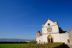 Church of San Francesco in Assisi with the stone wall. The basilica built in Gothic style houses the frescoes by Giotto and Cimabue. - MyVideoimage.com