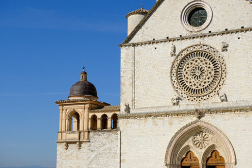 Church of San Francesco in Assisi with the stone wall. The basilica built in Gothic style houses the frescoes by Giotto and Cimabue. - MyVideoimage.com