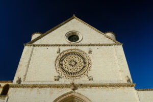 Church of San Francesco in Assisi with the stone wall. The basilica built in Gothic style houses the frescoes by Giotto and Cimabue. - MyVideoimage.com