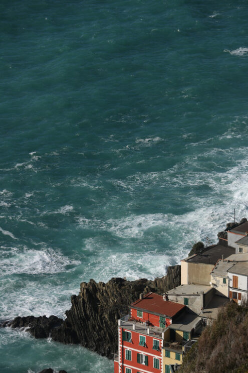 Cinque Terre panorama. Panorama of the village of Riomaggiore in the Cinque Terre. Rough sea with waves on the cliff. - MyVideoimage.com | Foto stock & Video footage