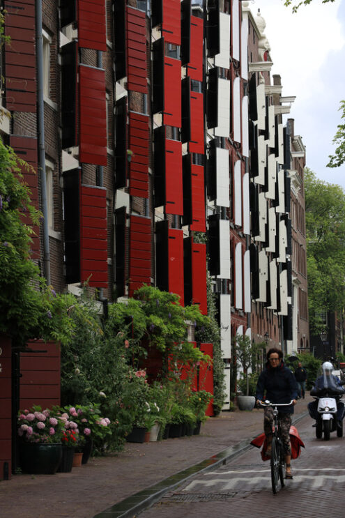 City street with building facade with red shutters and windows. - MyVideoimage.com